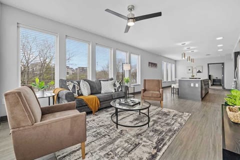 - Bright living room filled with natural light and modern seating  
- Open layout perfect for relaxing, gathering, and unwinding together  
- Large windows and stylish décor creating a warm inviting atmosphere  
