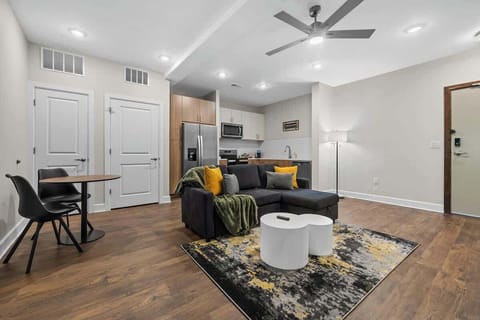 - Stylish open living room with cozy seating and bright modern decor  
- Wood floors and soft lighting create a welcoming Airbnb stay  
- Open layout connects lounge dining and kitchen for comfort  