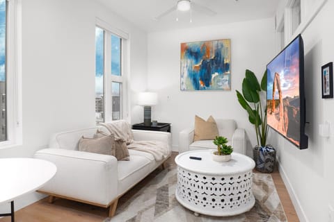 Beautifully designed living room. 65` TV, comfy sofa and amazing views of mountains and city skyline.