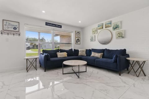Unwind in this bright and comfortable living space, featuring a plush, family-sized sofa perfect for movie nights, afternoon naps. Natural light pours in through large windows, creating a warm and welcoming atmosphere. 