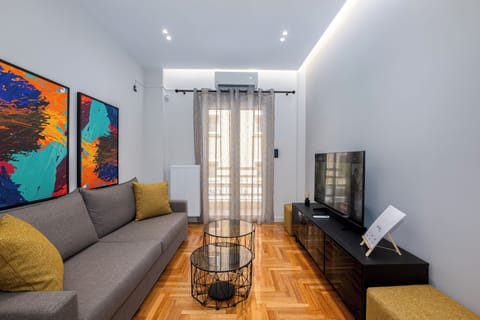 Cosy lounge with vibrant art, modern decor, and a sleek entertainment setup.
