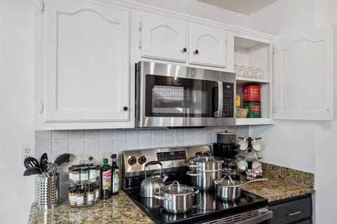 Cook with ease and flavor in the kitchen, featuring a full spice rack, quality stainless and ceramic cookware, plus organic olive oil and balsamic vinegar to elevate every meal.