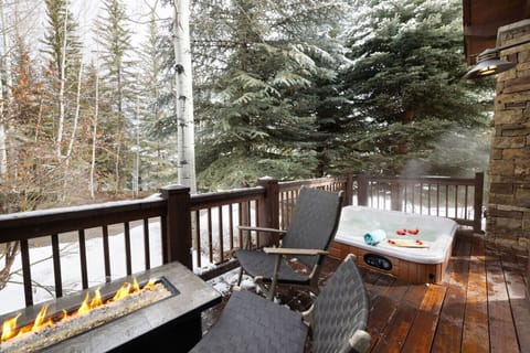 Cozy deck with a hot tub and fire pit.