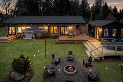 Idyllic private backyard with hot tub, fire pit, and several seating areas.