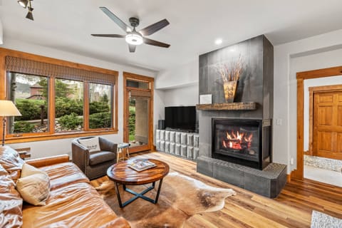 Stylish living with fireplace and comfortable seating around the television.