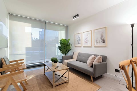 Relax in this modern living room filled with natural light, featuring stylish decor and a cozy atmosphere for your perfect getaway.
