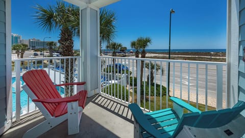 Relax on the balcony in colorful chairs with a refreshing beach view and enjoy the vibrant atmosphere of coastal living