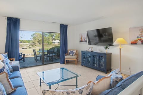 Spacious living area with a 65` Smart TV for streaming, a brand-new entertainment console (2026), and direct access to the back patio.