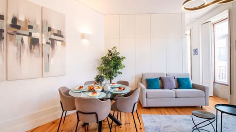Unwind in the spacious living room, perfect for relaxing on the comfortable sofa after a day of exploring, with the dining area conveniently nearby for shared meals. The warm wooden floors and stylish decor create an inviting ambiance.