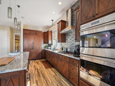 The modern kitchen offers sleek cabinetry and high-end appliances, making it a perfect hub for culinary enthusiasts and family gatherings in a beautifully designed space.