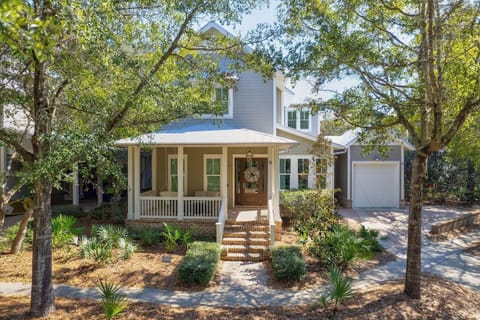 Charming house on a tree lined street with cozy front porch swing and seating.