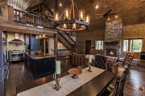 Warm cabin feel with open layout, gourmet kitchen, and fireplace.