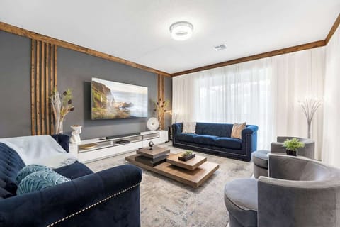 The living room has a modern design and offers an amazing view of the pool.