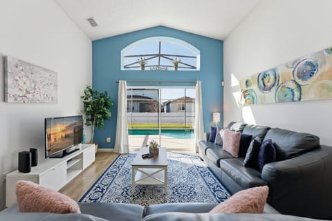 Harmonic and pleasant living room with a soothing blue wall and a stylish leather couch set.