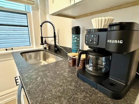 Enjoy your mornings in our modern Jungle House kitchen in Columbus! Our Keurig coffee maker is ready to fuel your adventures. & Our plants are looking forward to hosting you soon  Book your stay now and experience the perfect blend of comfort and