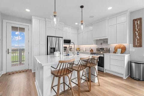 Kitchen with breakfast bar seating, pendant lighting, and open design—perfect for social gatherings.