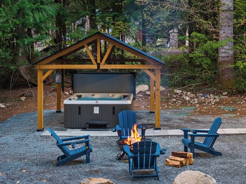 Covered hot tub with grill and fire pit in the forest