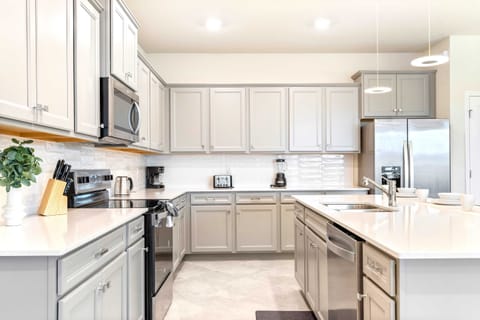 Bright, modern kitchen with full amenities, island seating, and sleek finishes