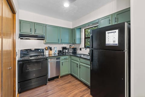Cook up memories in this well-equipped kitchen with stylish green cabinetry!