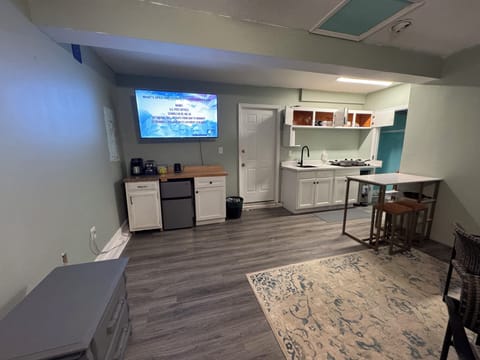 Kitchenette with a four-burner electric stove and mini fridge with freezer