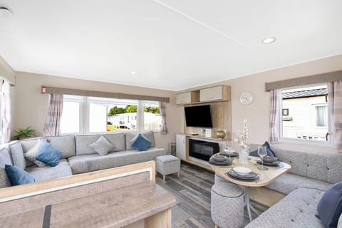 Modern and spacious holiday unit with comfortable seating, a cozy fireplace, and a smart TV. Enjoy natural light through large windows and a well-equipped dining area—perfect for relaxing and dining in style.
