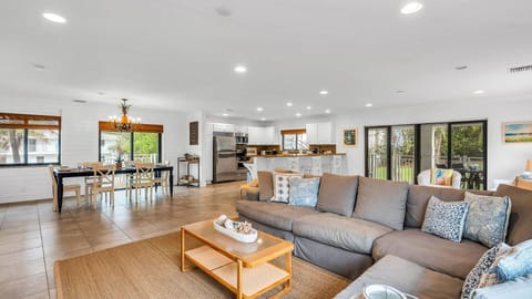 Spacious open floor plan featuring two inviting living room areas, smart TV, books, and games—perfect for relaxing or entertaining. Enjoy seamless access to the kitchen and a private balcony with outdoor dining for four.