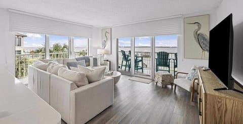 Bright living room overlooking the water, complete with comfy seating and deck access.