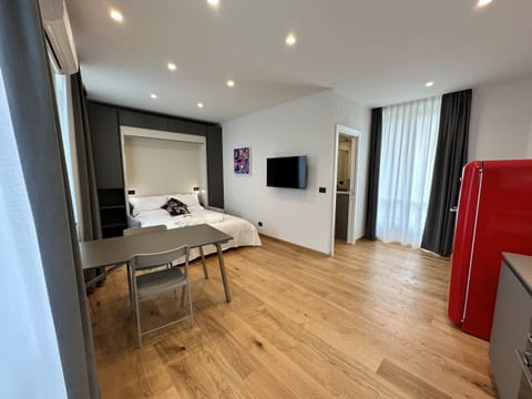 Bedroom/Living room equipped with a closet with a drop-down bed, SKY TV, closet for clothing, folding table and four folding chairs