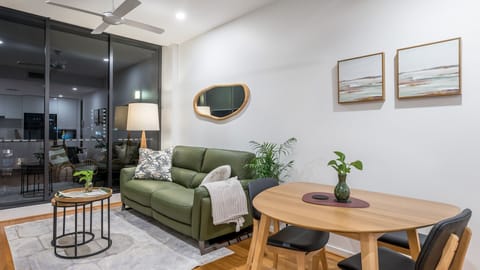 Living Room: Lighting/View: The room features a ceiling fan. Large glass doors at the back look out onto a balcony.