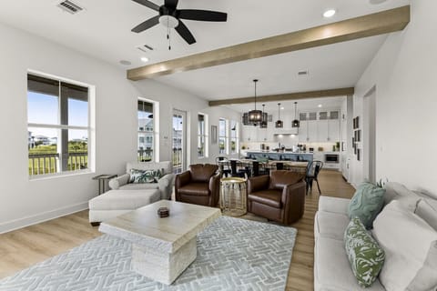 This bright, open-concept space blends the kitchen, dining, and living areas — all styled with a modern coastal touch and plenty of natural light