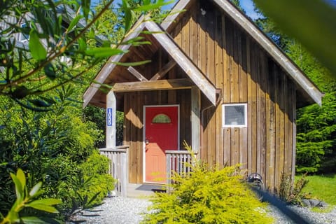 Charming cabin entrance with easy on-site parking, nestled in lush coastal greenery