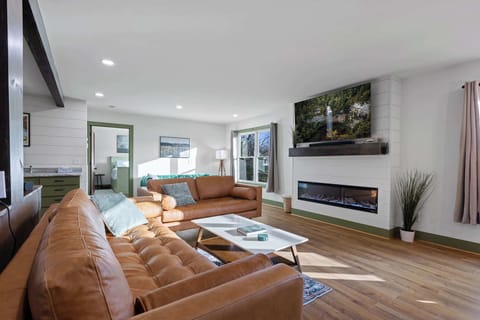 Unwind in comfort with two brown sofas and the warmth of a fireplace.