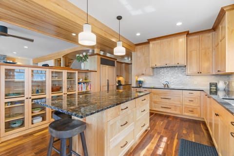 Your gourmet kitchen features warm wood cabinetry, granite counters, and a spacious island perfect for cooking memorable meals together.