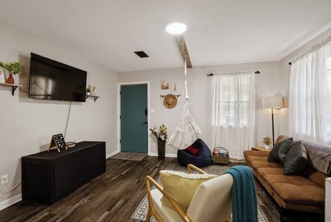 Bright open living area w/ comfy seating, TV & large windows letting in natural light