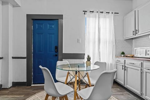 Compact and charming dining area by the window and blue door. Bright, airy, and welcoming.