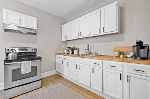 A fully equipped kitchen with stainless steel appliances and crisp white cabinetry. It offers ample counter space for cooking and meal preparation.
