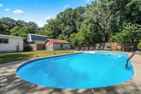 Sparkling backyard pool surrounded by trees & lawn, perfect for sunny afternoons outdoors