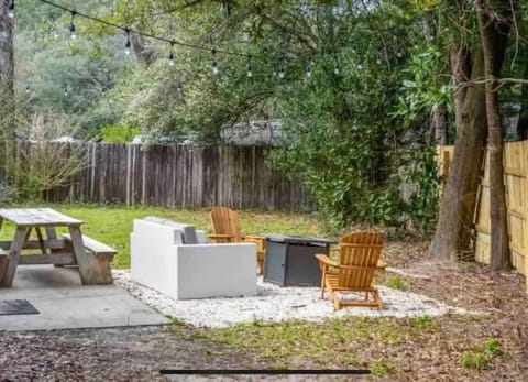 Private backyard w/ firepit seating & lush greenery, perfect for relaxing evenings outdoors