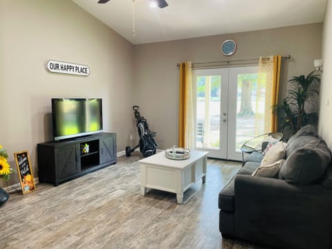 Bright and open living room with double doors leading to covered patio.