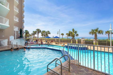Resort-style pool w/ lounge chairs, palm trees & a relaxed spot to cool off under the sun.