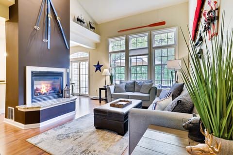 Main floor living area with gas fireplace, large windows and open floorplan 