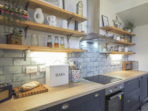 Kitchen with wooden shelves and built in hob.