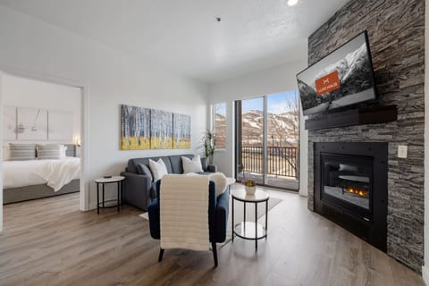 view of fireplace and living room with a large window and the view of the mountains from the balcony