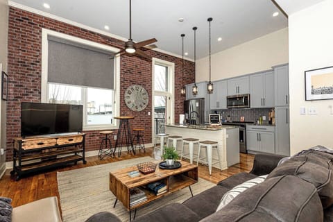 Living Room: Stylish space with exposed brick, modern furniture, and natural light!