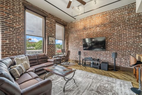 Living Room Retreat: Stylish brick walls, plush seating, and stunning views await your relaxation!