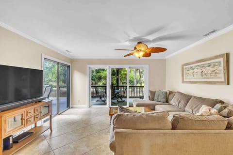 Relax in this spacious living room with a large sectional and natural light from sliding glass doors.