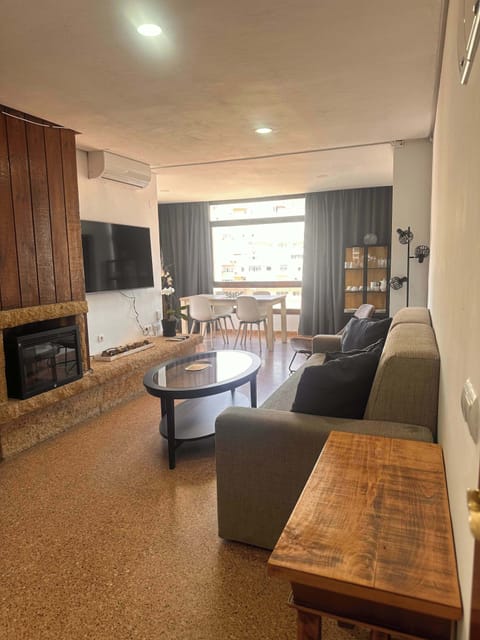 Espacio y acogedor salon-comedor con sofa cama doble, amplio ventanal y acceso a amplia terraza