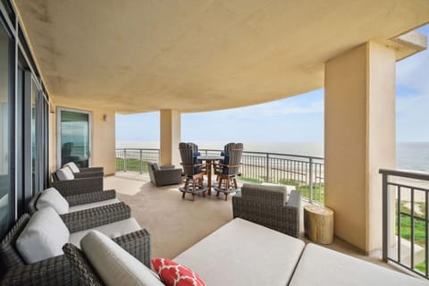 Spacious beachfront balcony with plush seating, high-top table for four, and panoramic Gulf views—perfect for relaxing or entertaining.
