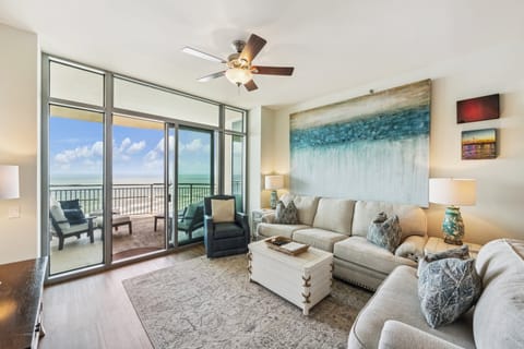 Bright and inviting living room at Palisade Palms with coastal views, modern decor, and seamless balcony access.
