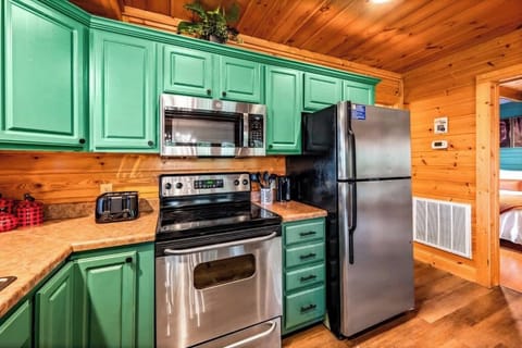 Kitchen: Vibrant green cabinets and modern appliances await your culinary adventures!